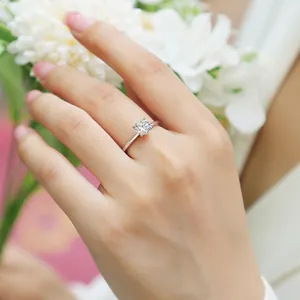 Classic six-prong 925 sterling silver moissanite ring worn on finger with soft lighting