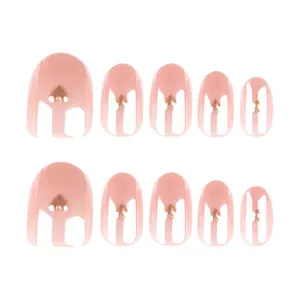 Short almond press-on nails in nude pink with golden heart metal charms, 10 piece set