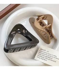 Close-up of minimalist triangle hair claw clip and khaki curved hollow hair shark clip