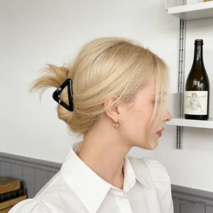 Minimalist black triangle hair claw clip for women shown on a model's hair