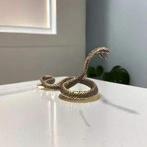 Detailed macro shot of a brass cobra figurine with intricate scales and coiled pose