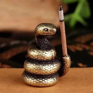 Macro view of vintage brass snake incense holder with detailed scale textures