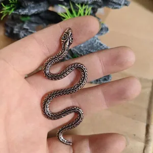 Macro di figurina di serpente in ottone vintage con scaglie dettagliate e corpo a forma di S