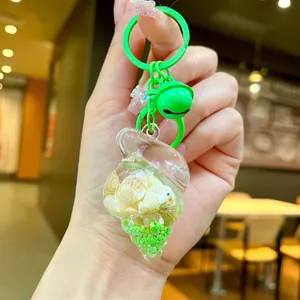 Macro shot of green seashell acrylic keychain with real tiny shells and bell pendant