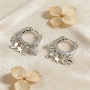 Detailed macro view of S925 sterling silver star and moon charms on hoop earrings