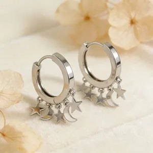 Elegant S925 sterling silver hoop earrings with star and moon charms on soft fabric