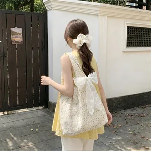Close-up of floral canvas tote bag with white lace bow and matching hair scrunchie