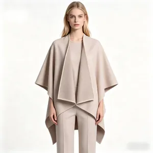 Detail view of a loose beige wool cape coat featuring elegant wide lapels and drape