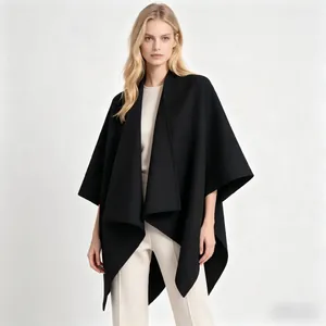 Detail of elegant black wool blend cape coat with oversized lapels and draped hemline