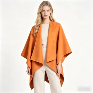 Detail of elegant orange wool poncho featuring asymmetric hem and layered shawl collar