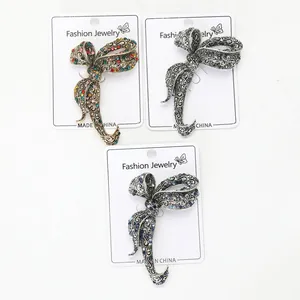 Three vintage bow brooches in gold, silver and black metal with crystal details