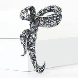 Macro shot of vintage silver bow brooch with blue and purple rhinestone detailing