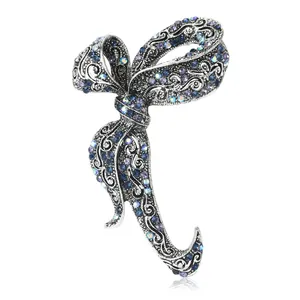 Elegant vintage bow brooch with blue and purple crystals on silver hollow metal