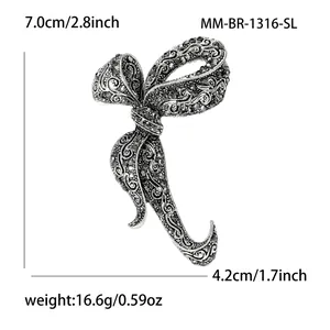 Vintage silver bow brooch with black rhinestones and intricate hollow patterns