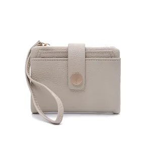 Close-up of beige lychee grain leather wallet showing wrist strap and card slots