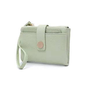 Close-up of mint green litchi texture leather purse with gold buckle and wrist strap
