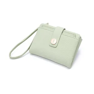 Close-up of mint green lychee textured PU leather wallet with golden buckle
