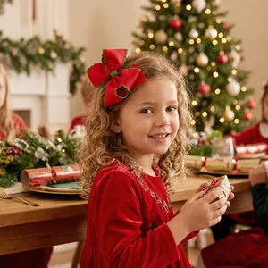 Gros plan d'une grande pince à cheveux nœud rouge de Noël avec couture verte