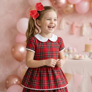 Fillette en robe écossaise avec col Claudine blanc dans un décor de fête d'anniversaire