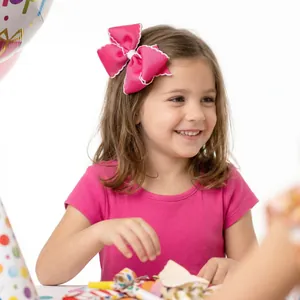 Détail du nœud papillon rose rouge à bords ondulés pour cheveux de petite fille