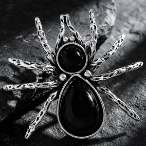 Macro shot of gothic spider brooch with vintage silver texture and black gemstones