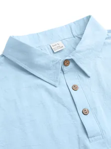 Close-up of light blue linen polo shirt collar with three dark wood buttons