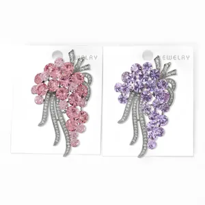 Detailed view of pink and purple crystal grape brooches with sparkling leaf accents