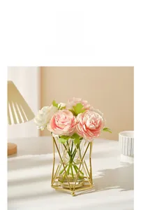Détail d'un bouquet de roses réalistes dans un vase en verre avec cadre en métal doré