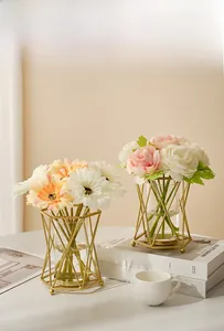 Vase géométrique doré nordique avec fleurs artificielles sur livres de décoration