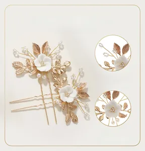 Detail of handcrafted ceramic flower and gold leaf hair pins with pearl accents