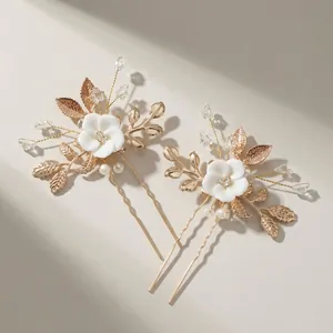 Golden bridal hair pin set with white ceramic flowers, pearls and leaf accents