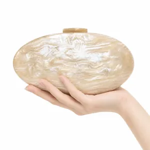 Detailed macro view of an oval marble acrylic clutch bag with a gold metal clasp