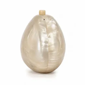 Macro detail of oval acrylic clutch bag featuring elegant champagne marble texture