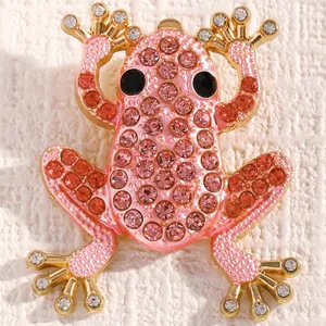 Makroaufnahme einer Froschbrosche mit rosa und roten Steinchen auf Goldlegierung