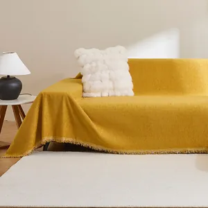 Detalle de la funda de sofá de chenilla amarillo brillante con elegantes flecos