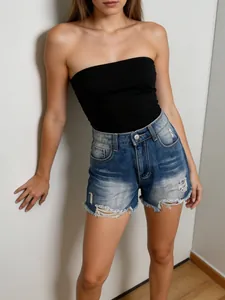 Women high waisted distressed denim shorts with frayed hem and black tube top