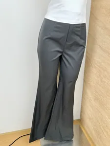 Detail showing high-waisted dark grey flare pants with slim fit and elegant drape effect
