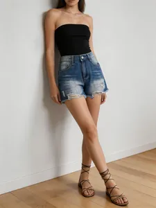 Close-up of high-waisted dark blue denim shorts with ripped details and frayed hems