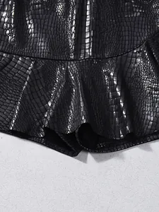 Detail of black faux leather skirt with embossed crocodile texture and ruffled hem