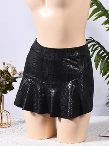 Detail of black faux leather mini skirt with embossed crocodile texture and ruffle hem