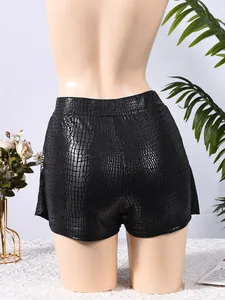 Detail shot of black faux leather high waisted shorts with crocodile skin texture
