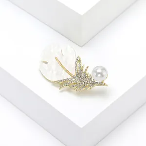 Elegant leaf brooch with white shell petals, golden branches and a white pearl accent