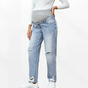 Close-up of maternity jeans featuring distressed knee holes and high elastic waist band
