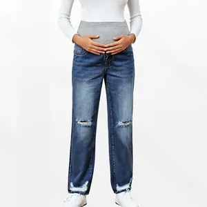 Detail of high waist maternity jeans with grey belly support band and ripped knees