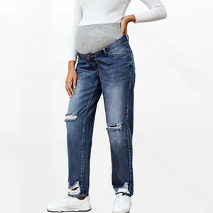 Detail of high waist maternity jeans with elastic belly support and ripped knees