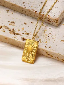 Detailed macro view of gold plated rectangle pendant with hammered texture and sunburst star