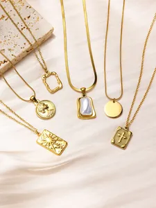 Detailed shot of assorted gold titanium necklaces with coin and cross pendants