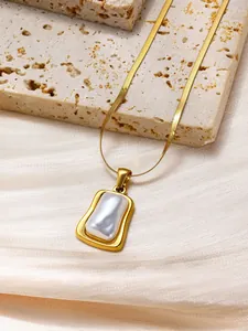 Detail of minimalist gold snake chain with irregular rectangle shell pendant on silk