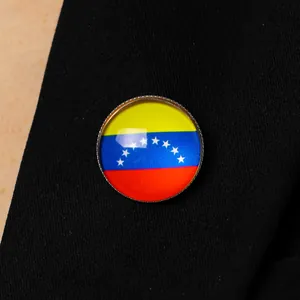 Close-up of Venezuela flag round lapel pin with glossy glass dome on black fabric
