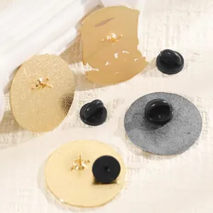 Detail view of gold and silver metal brooch backs with durable black rubber clutch backs
